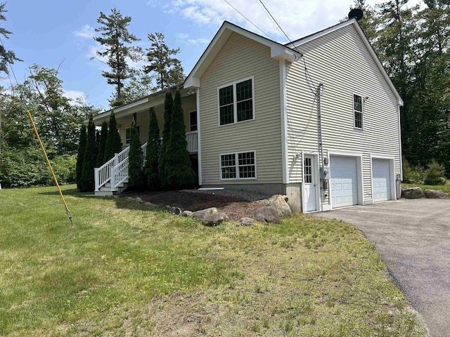 142 Eagle Shore Rd, Moultonborough, NH 03254 - view of side of home featuring asphalt driveway, a garage, covered porch, and a yard