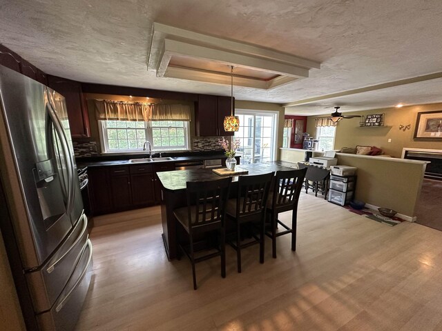 2 Cobblestone Pl, Merrimack, NH 03054 - kitchen with stainless steel refrigerator with ice dispenser, dark countertops, light wood-type flooring, decorative backsplash, and a tray ceiling
