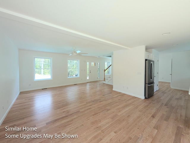 8 Meindl Rd Unit 1, Raymond, NH 03077 - unfurnished living room featuring stairs, light wood finished floors, and a ceiling fan