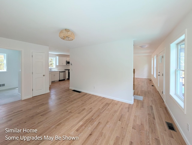 8 Meindl Rd Unit 1, Raymond, NH 03077 - unfurnished living room with light wood finished floors and healthy amount of natural light