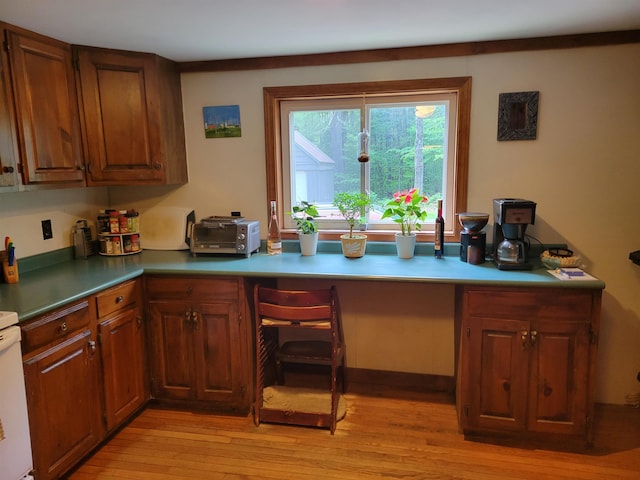 49 Tabor Cir, Albany, NH 03818 - kitchen with built in desk, light wood finished floors, and brown cabinets