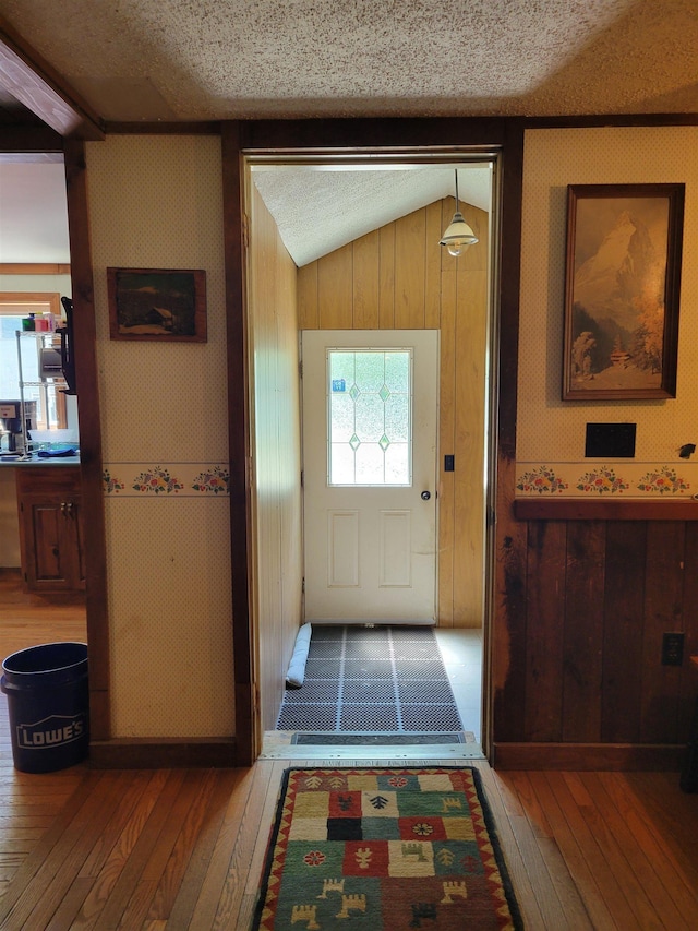 49 Tabor Cir, Albany, NH 03818 - doorway with hardwood / wood-style floors, a textured ceiling, vaulted ceiling, and wooden walls