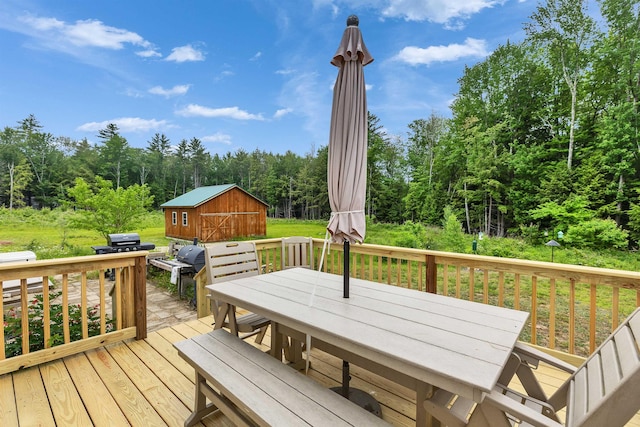 21 Burke Rd, Peterborough, NH 03458 - deck featuring outdoor dining space, an outbuilding, and a view of trees