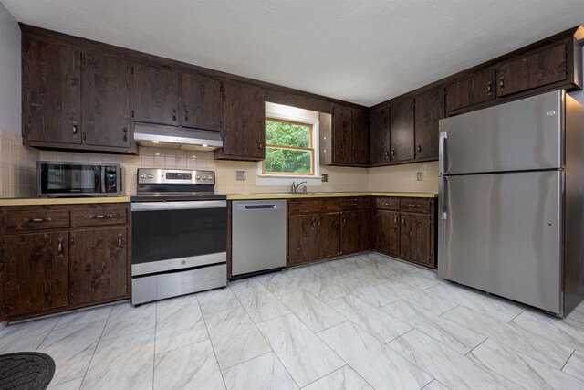 8 Jakes Ln, Merrimack, NH 03054 - kitchen with appliances with stainless steel finishes, under cabinet range hood, light marble finish floors, and dark brown cabinets