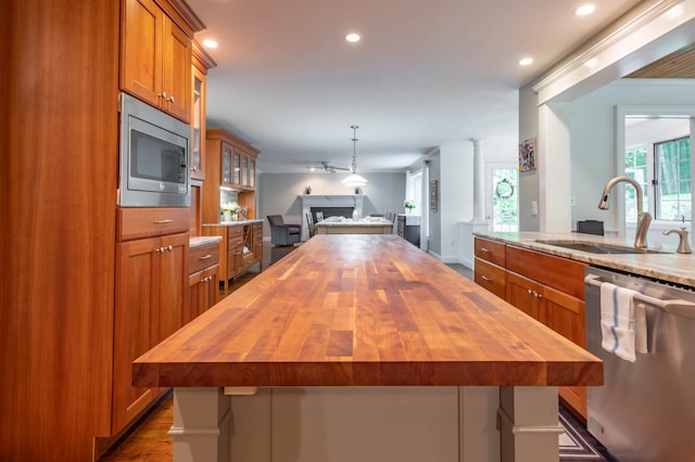 35 Fletcher Ln, Hollis, NH 03049 - kitchen with butcher block countertops, stainless steel appliances, brown cabinetry, open floor plan, and recessed lighting