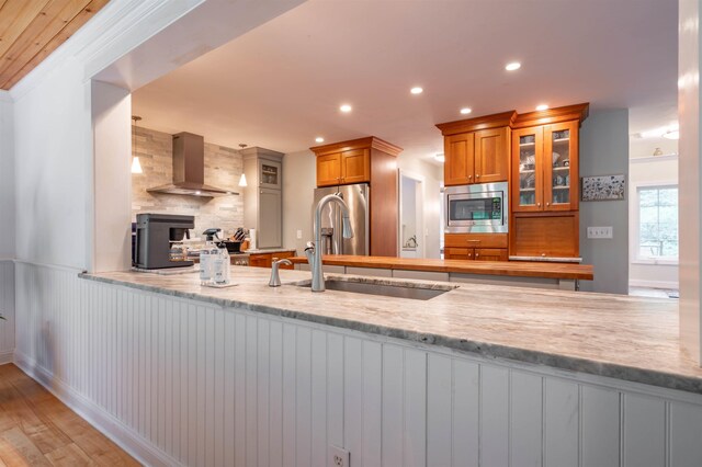 35 Fletcher Ln, Hollis, NH 03049 - kitchen featuring exhaust hood, appliances with stainless steel finishes, brown cabinets, decorative backsplash, and glass insert cabinets