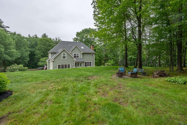 35 Fletcher Ln, Hollis, NH 03049 - rear view of house with a chimney, a lawn, and a forest view