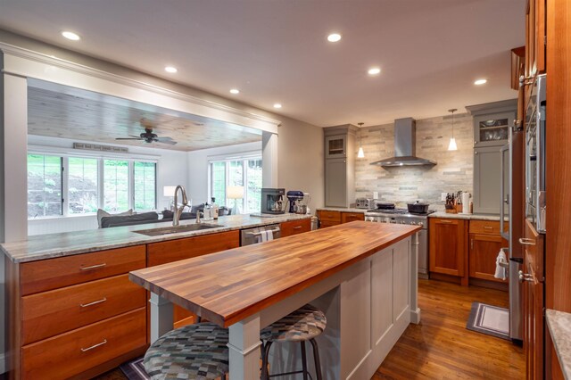 35 Fletcher Ln, Hollis, NH 03049 - kitchen featuring wall chimney range hood, wooden counters, appliances with stainless steel finishes, recessed lighting, and decorative backsplash
