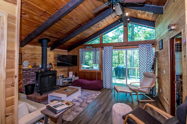 25 Singer Ln, Conway, NH 03813 - living room with wood finished floors, wood walls, a ceiling fan, a wood stove, and wood ceiling