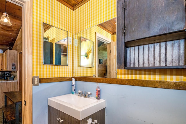 25 Singer Ln, Conway, NH 03813 - bathroom with wallpapered walls, vaulted ceiling, and vanity