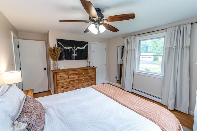 71/2 Olesen Rd, Derry, NH 03038 - bedroom with a baseboard heating unit, light wood-style floors, and a ceiling fan