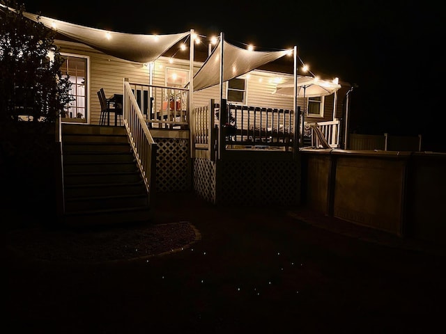 71/2 Olesen Rd, Derry, NH 03038 - back of house at night featuring a deck and stairs