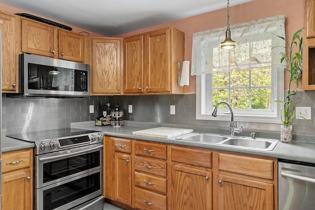 245 W River Rd, Hooksett, NH 03106 - kitchen featuring stainless steel appliances, light countertops, tasteful backsplash, decorative light fixtures, and brown cabinetry
