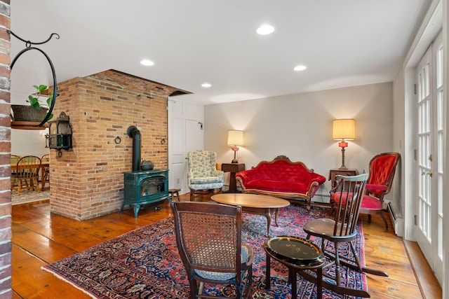 85 Dartmouth College Hwy Unit 204, Lyme, NH 03768 - living area with wood-type flooring, a wood stove, brick wall, plenty of natural light, and recessed lighting