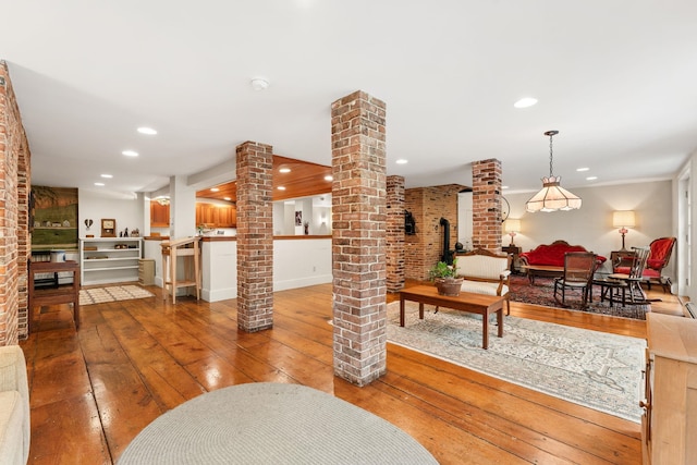 85 Dartmouth College Hwy Unit 204, Lyme, NH 03768 - living area with ornate columns, wood-type flooring, brick wall, and recessed lighting