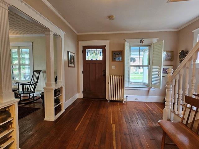 93 S Lincoln St, Keene, NH 03431 - entryway featuring radiator, dark wood-type flooring, plenty of natural light, decorative columns, and ornamental molding