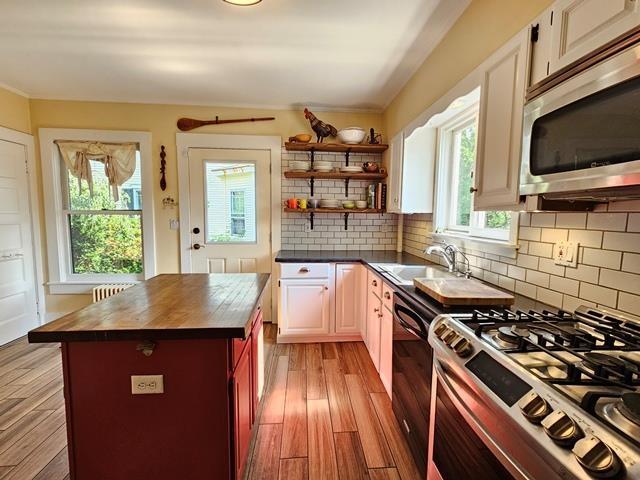 93 S Lincoln St, Keene, NH 03431 - kitchen with appliances with stainless steel finishes, wooden counters, decorative backsplash, and light wood-style flooring