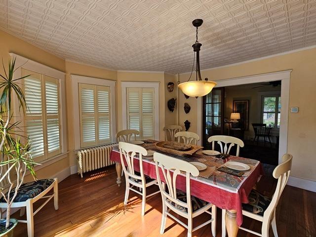 93 S Lincoln St, Keene, NH 03431 - dining area featuring radiator, an ornate ceiling, and wood finished floors