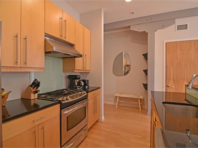 161 St Paul St Unit 202, Burlington, VT 05401 - kitchen with stainless steel gas range, under cabinet range hood, dark countertops, light wood-style floors, and recessed lighting