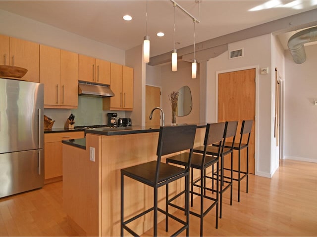 161 St Paul St Unit 202, Burlington, VT 05401 - kitchen with freestanding refrigerator, under cabinet range hood, dark countertops, light wood-style flooring, and recessed lighting