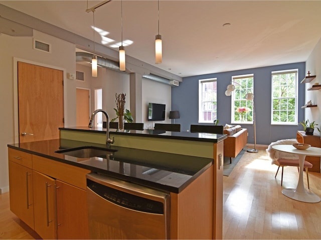 161 St Paul St Unit 202, Burlington, VT 05401 - kitchen with stainless steel dishwasher, dark countertops, open floor plan, a center island with sink, and plenty of natural light