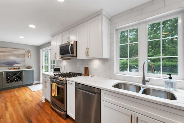 12 Julia Dr, Hooksett, NH 03106 - kitchen with stainless steel appliances, recessed lighting, white cabinets, tasteful backsplash, and light stone countertops