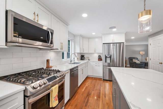 12 Julia Dr, Hooksett, NH 03106 - kitchen with appliances with stainless steel finishes, light wood-style flooring, tasteful backsplash, white cabinets, and recessed lighting