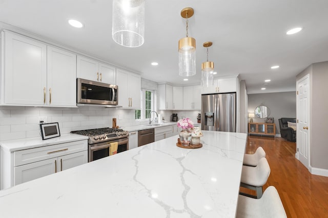 12 Julia Dr, Hooksett, NH 03106 - kitchen with appliances with stainless steel finishes, white cabinets, recessed lighting, backsplash, and decorative light fixtures