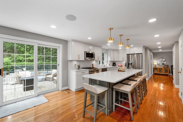 12 Julia Dr, Hooksett, NH 03106 - kitchen with stainless steel appliances, light wood-style flooring, a kitchen bar, white cabinets, and recessed lighting