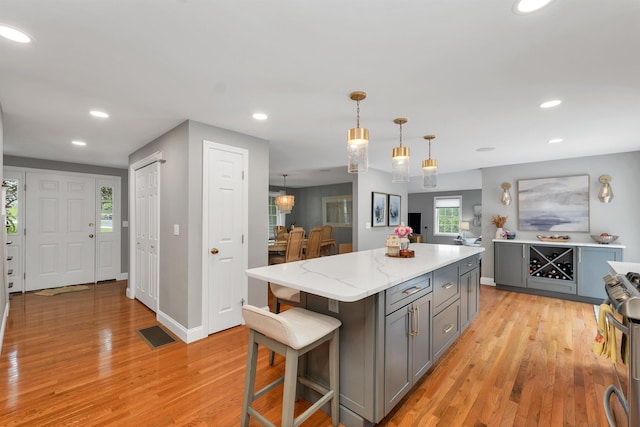 12 Julia Dr, Hooksett, NH 03106 - kitchen with gray cabinetry, stainless steel range oven, light wood-style flooring, recessed lighting, and hanging light fixtures