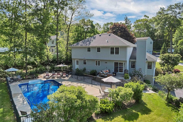 12 Julia Dr, Hooksett, NH 03106 - back of property with a patio area, view of scattered trees, and roof with shingles