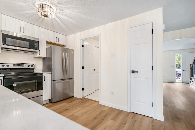 48 Eastmeadow Way, Manchester, NH 03109 - kitchen featuring stainless steel appliances, light wood-type flooring, white cabinets, light countertops, and a textured ceiling
