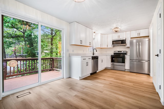 48 Eastmeadow Way, Manchester, NH 03109 - kitchen with appliances with stainless steel finishes, light countertops, light wood-type flooring, and white cabinetry