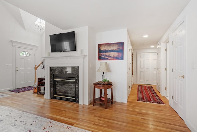 127 Hampton Mdws, Hampton, NH 03842 - living area featuring wood finished floors, recessed lighting, a glass covered fireplace, a chandelier, and vaulted ceiling