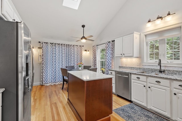 127 Hampton Mdws, Hampton, NH 03842 - kitchen featuring appliances with stainless steel finishes, a ceiling fan, backsplash, white cabinetry, and healthy amount of natural light