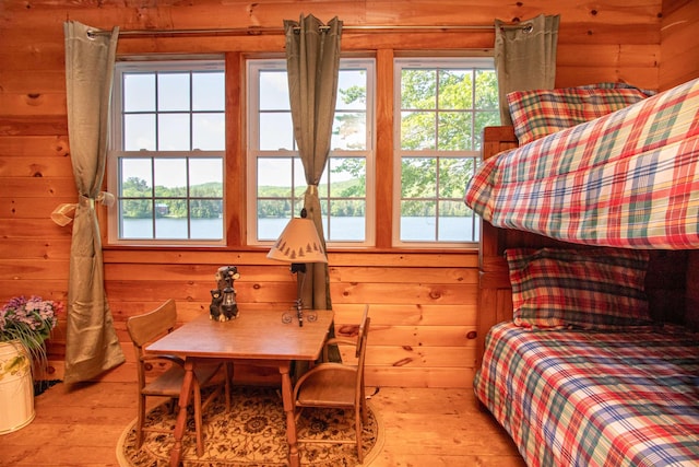 491 The Ln, Peacham, VT 05862 - bedroom featuring wooden walls, light wood-type flooring, and multiple windows