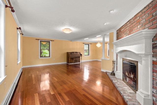 90 Giles Rd, East Kingston, NH 03827 - unfurnished living room featuring a baseboard heating unit, ornate columns, wood finished floors, a brick fireplace, and plenty of natural light