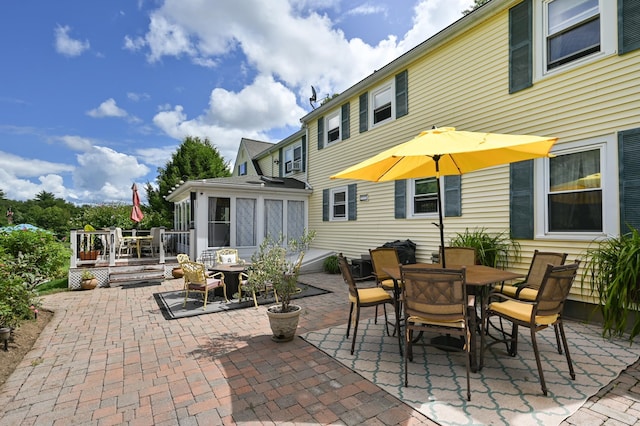 90 Giles Rd, East Kingston, NH 03827 - view of patio with outdoor dining area, a wooden deck, and a sunroom