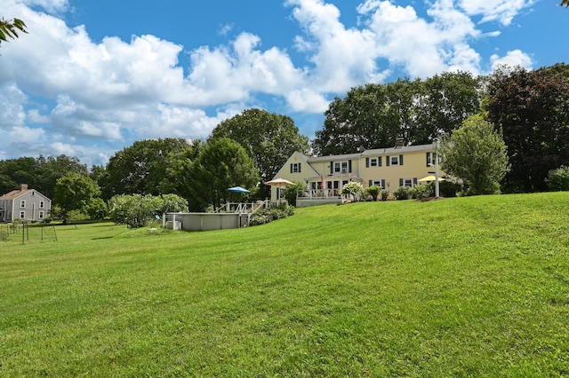 90 Giles Rd, East Kingston, NH 03827 - view of green lawn with a covered pool and view of wooded area