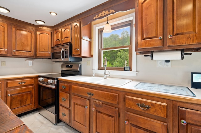 90 Giles Rd, East Kingston, NH 03827 - kitchen with appliances with stainless steel finishes, brown cabinets, light countertops, light tile patterned floors, and recessed lighting