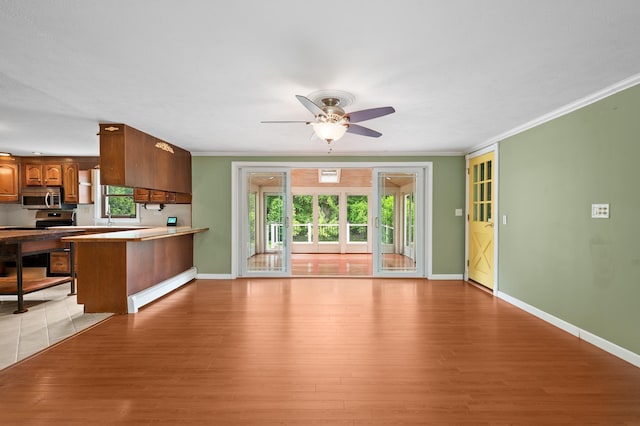 90 Giles Rd, East Kingston, NH 03827 - kitchen featuring stainless steel appliances, brown cabinetry, a peninsula, ceiling fan, and light wood-style floors