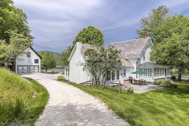 331 Rte 100 N, Plymouth, VT 05056 - view of property exterior with a chimney, a patio, a lawn, a detached garage, and a mountain view