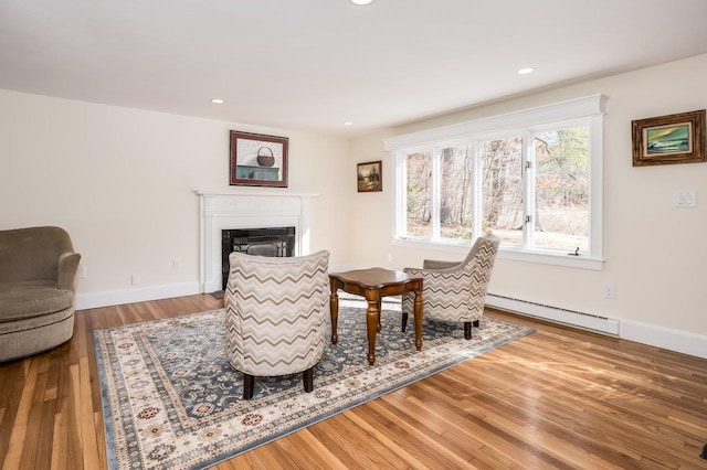 8 Woodridge Rd, Durham, NH 03824 - living area with a baseboard heating unit, a glass covered fireplace, wood finished floors, and recessed lighting