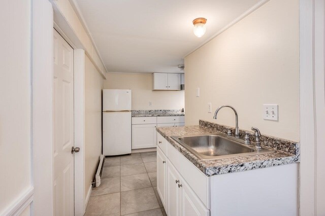 8 Woodridge Rd, Durham, NH 03824 - kitchen with freestanding refrigerator, light tile patterned floors, and white cabinets