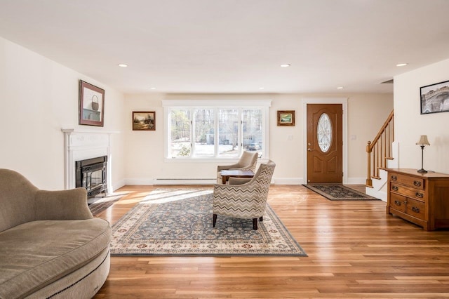 8 Woodridge Rd, Durham, NH 03824 - living area with stairway, a fireplace with flush hearth, light wood-type flooring, recessed lighting, and a baseboard radiator