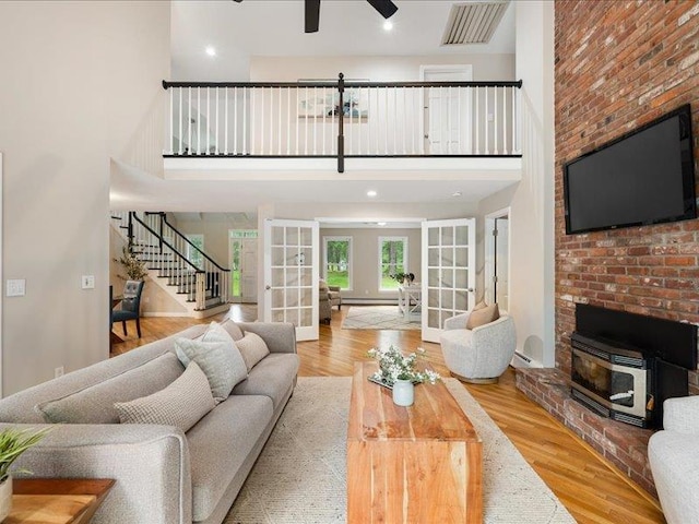 71 Marblehead Rd, Windham, NH 03087 - living room featuring french doors, stairs, a wood stove, ceiling fan, and wood finished floors