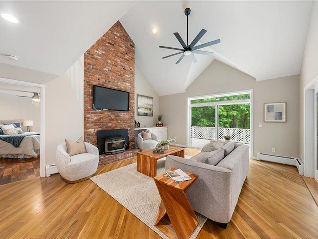 71 Marblehead Rd, Windham, NH 03087 - living area featuring a ceiling fan, a baseboard radiator, a wood stove, light wood-style flooring, and high vaulted ceiling