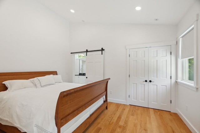 68 Sewall Rd, Wolfeboro, NH 03894 - bedroom featuring multiple windows, light wood-style floors, recessed lighting, a barn door, and a closet