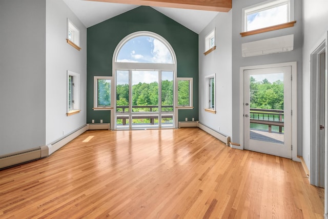 650 Perry Lea Rd, Waterbury, VT 05676 - spare room with high vaulted ceiling, wood finished floors, baseboard heating, and a wall mounted air conditioner
