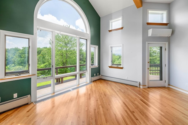650 Perry Lea Rd, Waterbury, VT 05676 - unfurnished living room with a baseboard radiator, high vaulted ceiling, wood finished floors, healthy amount of natural light, and beamed ceiling